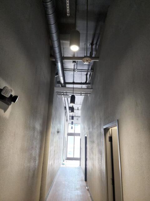 Hanging lights light up a dark hallway in an office building